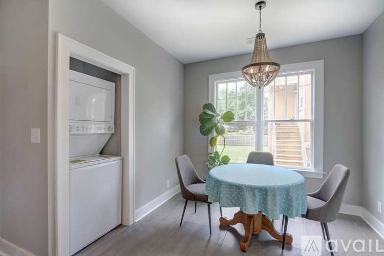 A dining room with a round table and chairs.