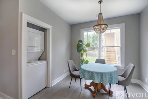 A dining room with a round table and chairs.