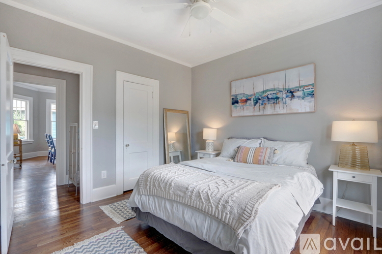A bedroom with a large bed and a painting on the wall.