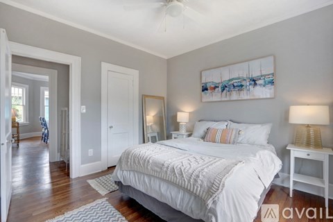 A bedroom with a large bed and a painting on the wall.