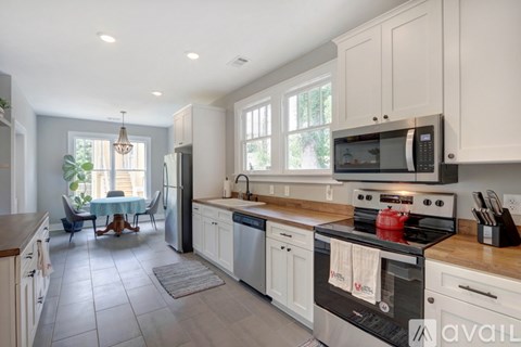 A kitchen with white cabinets and a black stove top oven.