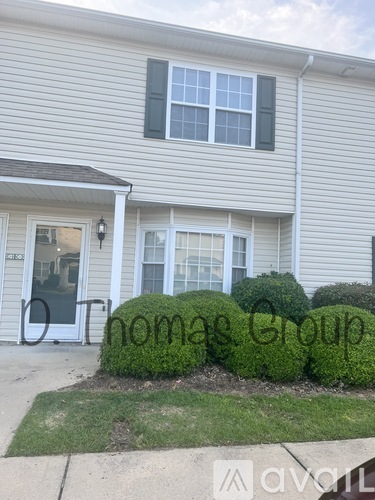 A house with a sign that says "Thomas Group" in front of it.