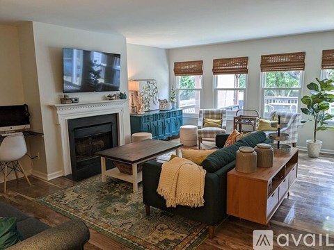 A living room with a fireplace and a television on the wall.