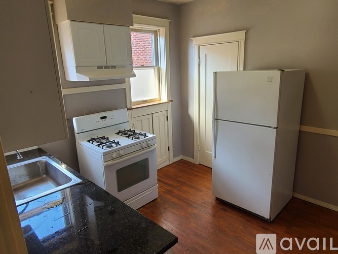A kitchen with a white fridge, stove and oven.
