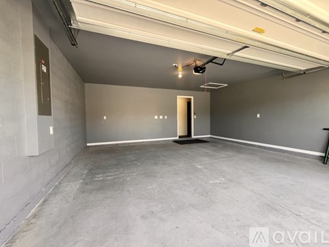 A spacious empty room with a concrete floor and grey walls.