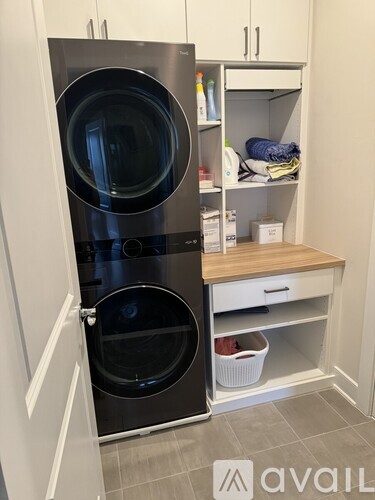 A black front loading dishwasher is open and placed in a kitchen.