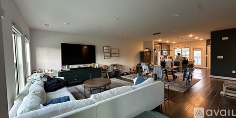 A living room with a white couch and a television.