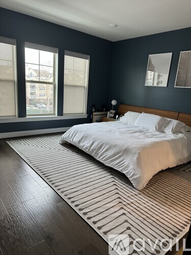 A bedroom with a large bed and a striped rug.