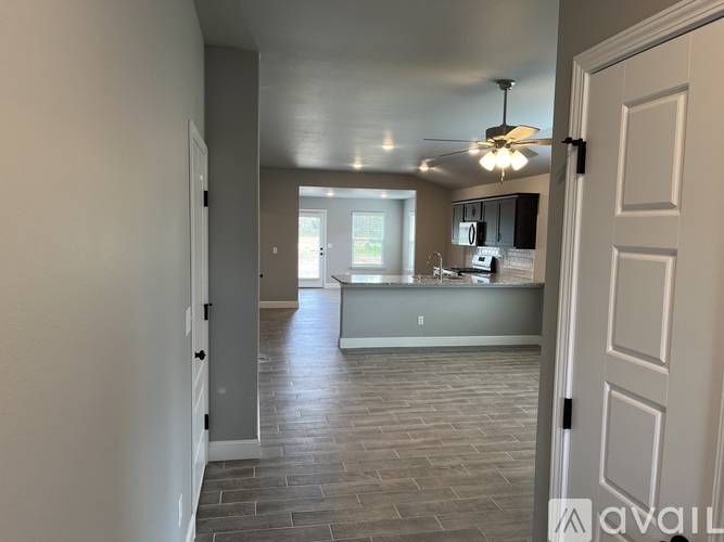 A spacious kitchen with a dining area in the background.