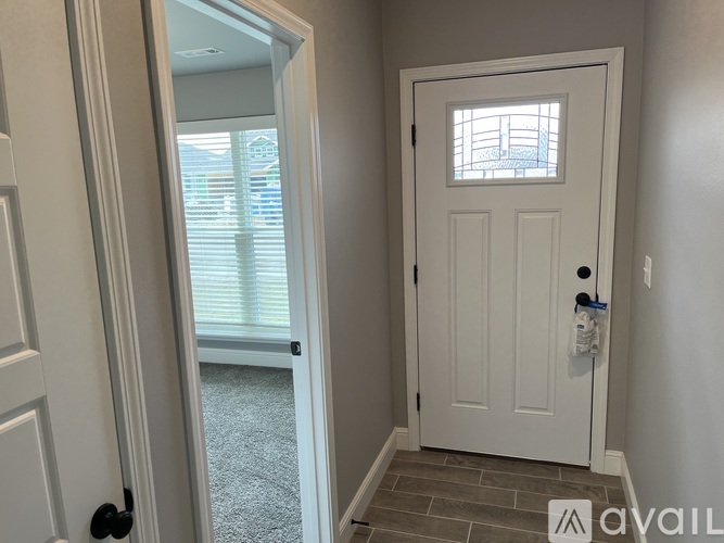 A white door with a black handle is in a room with a carpeted floor.
