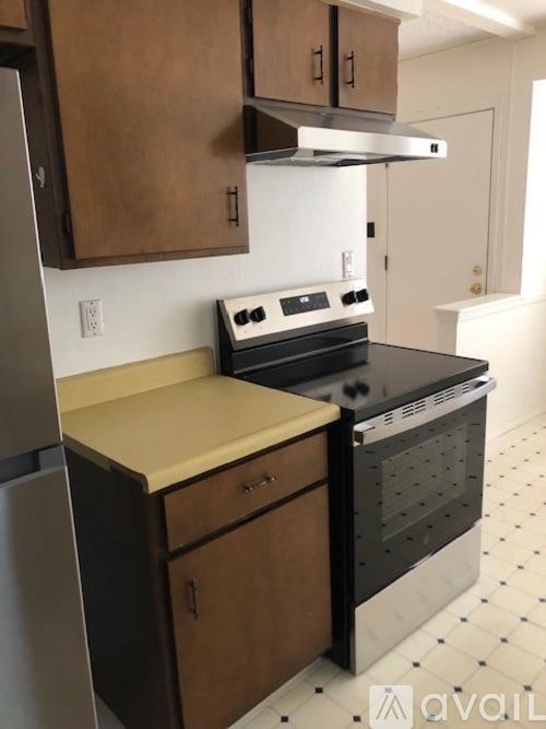 A kitchen with a black oven and a black and white floor.