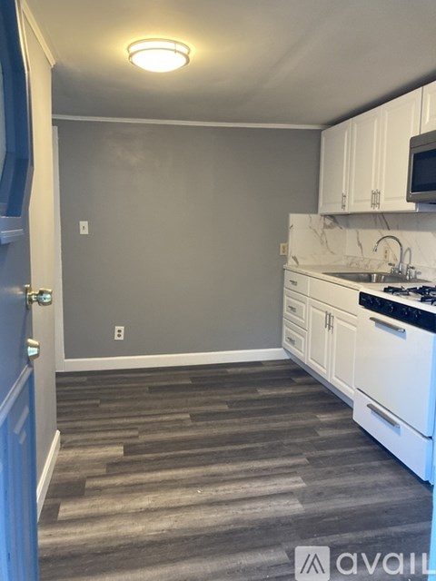 A kitchen with white cabinets and a black stove top oven.