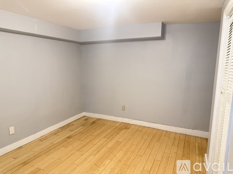 A room with wooden flooring and grey walls.