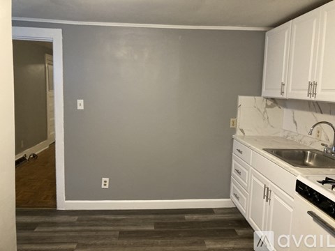 A kitchen with white cabinets and a marble countertop.