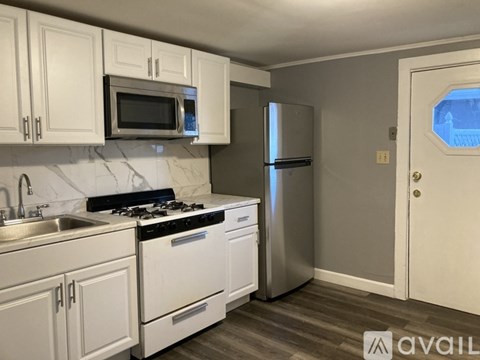 A kitchen with white cabinets and appliances.