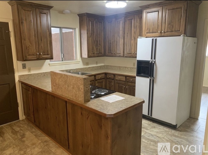 A kitchen with wooden cabinets and a white refrigerator.