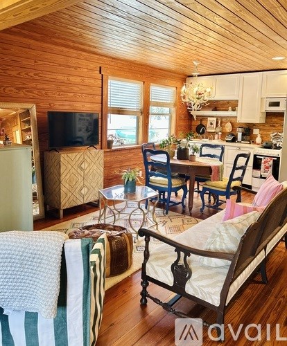 A living room with a sofa, chairs, and a television.