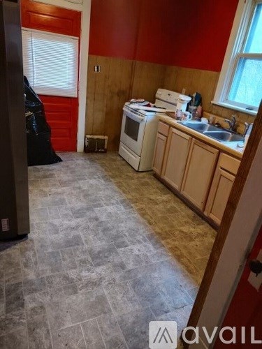 A kitchen with a white stove top oven and a white dishwasher.