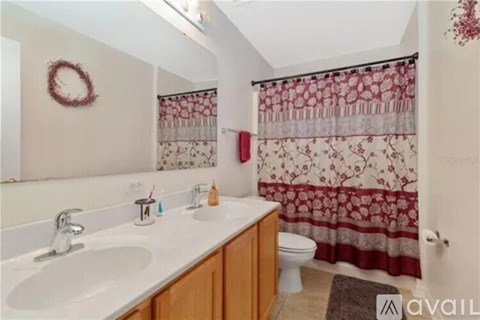A bathroom with a white sink and a red wreath on the wall.