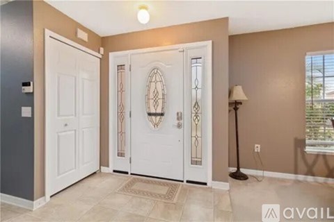 A room with a white door, a window, and a lamp.
