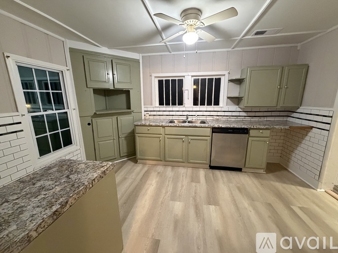 A kitchen with wooden floors and a marble countertop.
