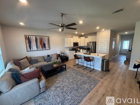 A living room with a grey couch, a coffee table, and a painting on the wall.