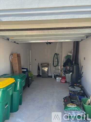 A storage space with green bins and a ladder.