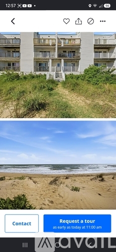 A beachfront apartment complex with a sandy beach in the foreground.