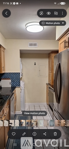 A kitchen with wooden cabinets and a stainless steel refrigerator.