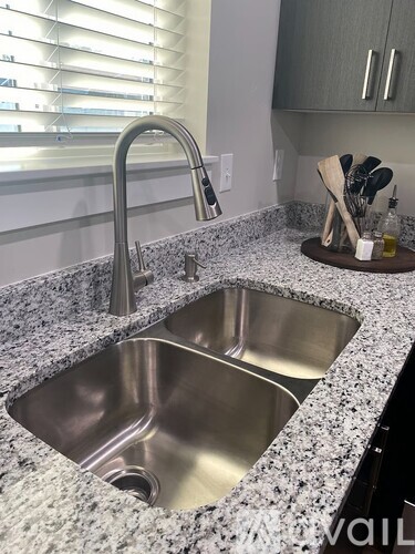 A kitchen sink with a granite countertop and a faucet.