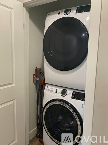 A white washing machine and dryer stacked on top of each other in a small space.