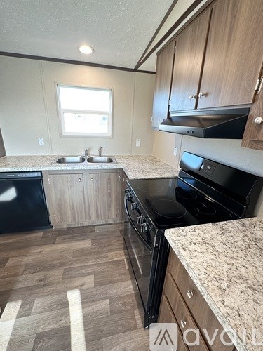 A kitchen with wooden cabinets and black appliances.