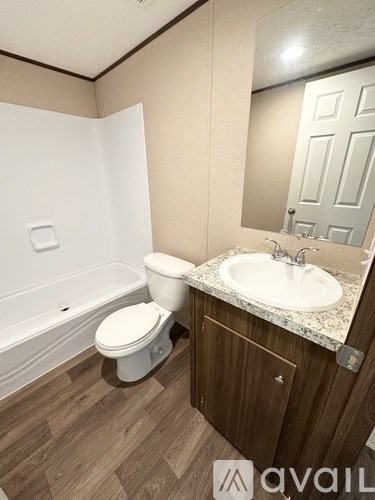 A bathroom with a toilet, sink, and bathtub.