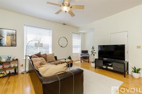 A living room with a brown couch and a flat screen TV.