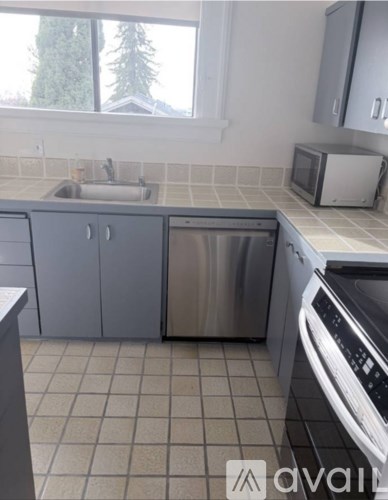 A kitchen with a dishwasher and a microwave.