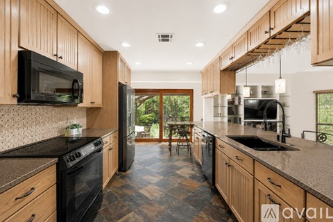 A kitchen with wooden cabinets and black appliances.