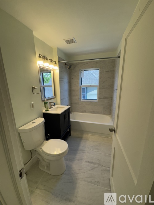 A bathroom with a toilet, sink, and bathtub.