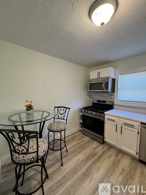 A kitchen with a glass table and chairs.