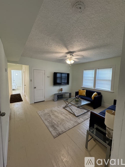 A living room with a couch, coffee table, and television.