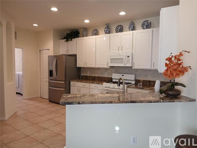 A kitchen with granite countertops and white cabinets.