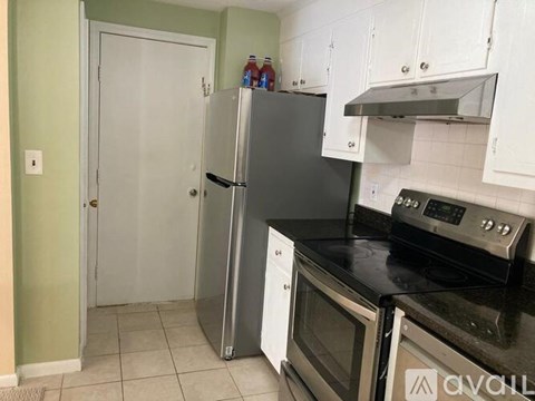 A kitchen with white cabinets and a black countertop.