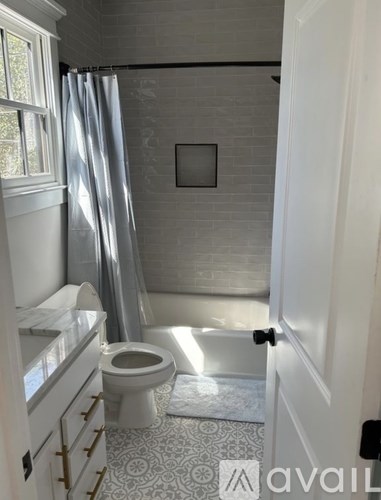 A bathroom with a toilet, sink, and shower.