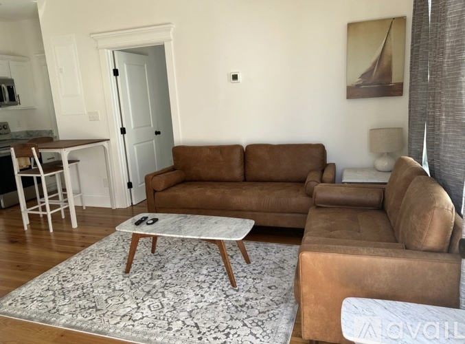 A living room with a brown couch and a coffee table.