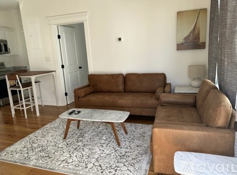 A living room with a brown couch and a coffee table.