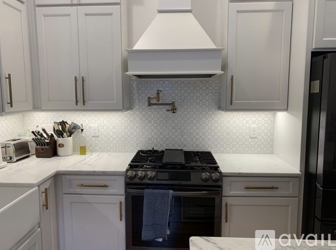 A kitchen with white cabinets and a black stove top oven.