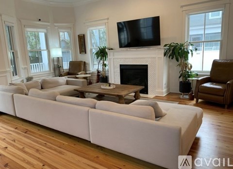 A living room with a white couch and a fireplace.