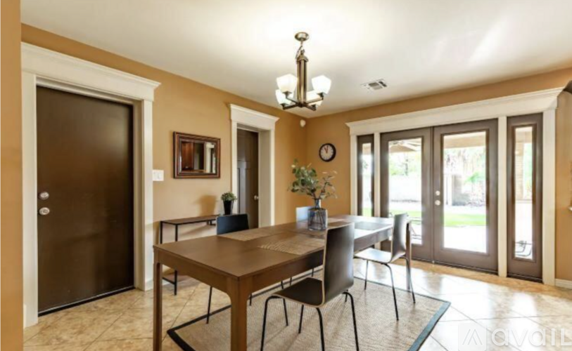 A dining room with a wooden table and chairs.