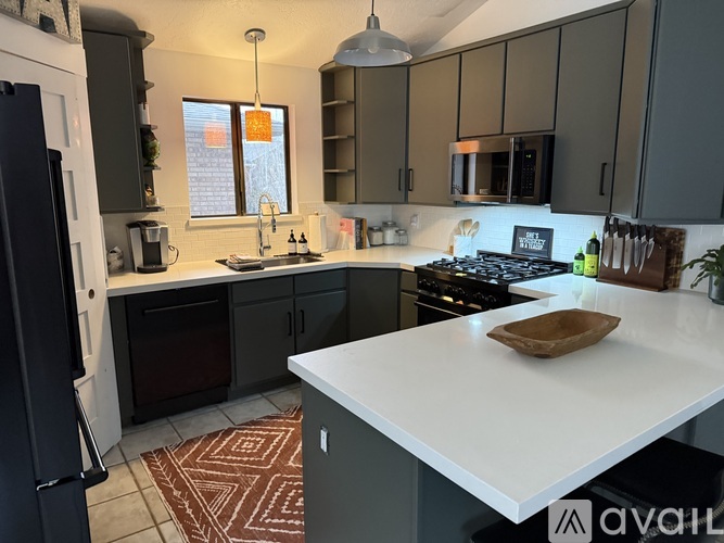 A kitchen with a white countertop and dark cabinets.