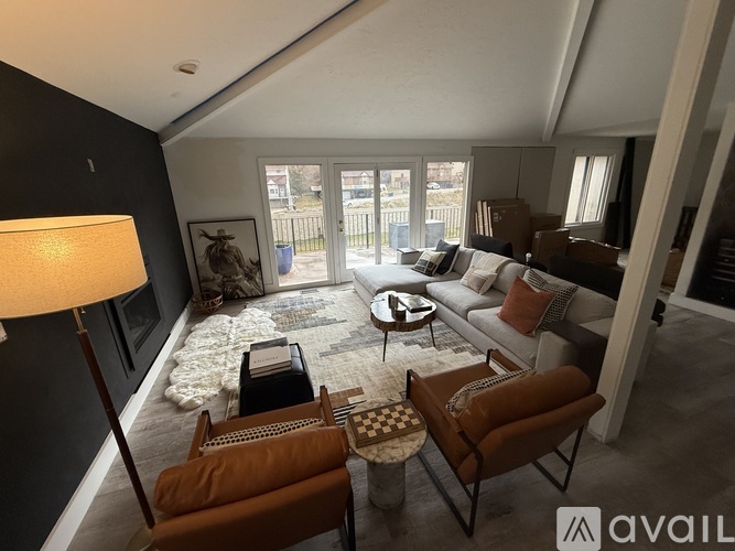 A living room with a rug, a sofa, a chair, and a lamp.