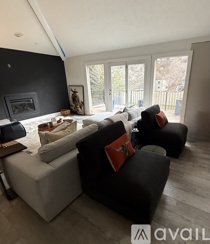 A living room with a white couch and a black couch.